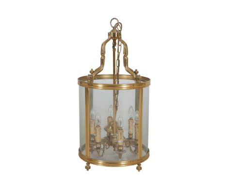 A 19TH CENTURY STYLE SIX LIGHT BRASS HALL LANTERN, the cylindrical glass body surmounted by four scrolling arms, terminating 