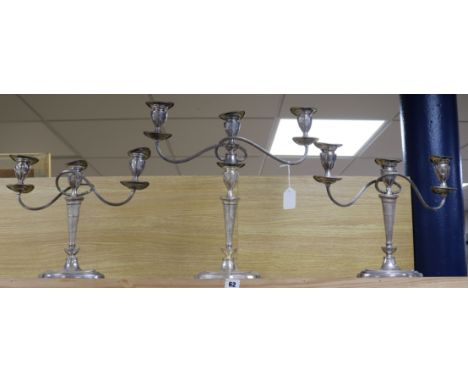 A suite of three silver plated two branch three light oval candelabra, comprising a pair and larger single, tallest 45.5cm.