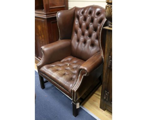 A leather button back wing armchair