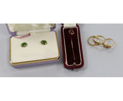 Three 18ct gold rings including two gem set, a pair of ear studs and a stick pin.