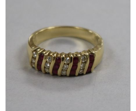 A modern 14ct gold ruby and diamond cluster half hoop ring, size M.