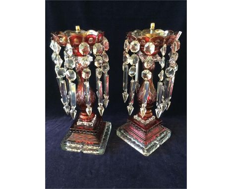 A pair of cranberry and cut glass candlestick/lamp bases