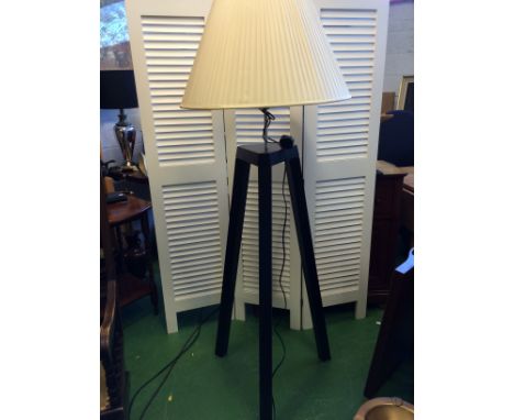 Back tripod standard lamp with white pleated shade.