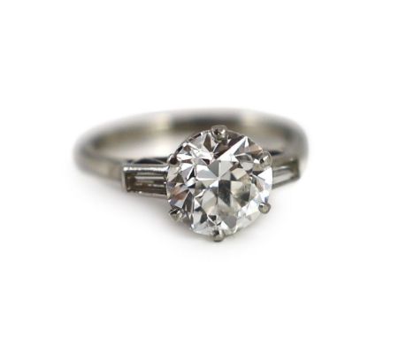 A mid 20th century platinum and single stone diamond ring, with trapeze cut diamond set shoulders, the central stone weighing