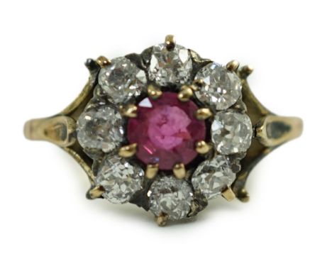 An antique gold, ruby and old cut diamond set circular cluster ring, size K, gross 4.6 grams.Some tarnish spots to the shank 