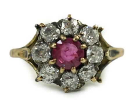 An antique gold, ruby and old cut diamond set circular cluster ring, size K, gross 4.6 grams.Some tarnish spots to the shank 