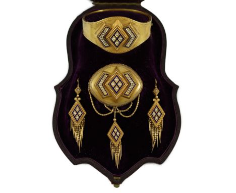A cased Victorian gold, seed pearl and blue enamel parure, comprising a hinged bangle, tassel pendant brooch and pair of tass