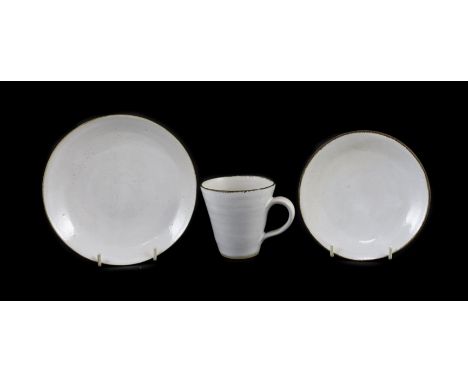 Dame Lucie Rie (1902-1995) a cup, saucer and side plate, c.1959, each white glazed stoneware with manganese rims, impressed L