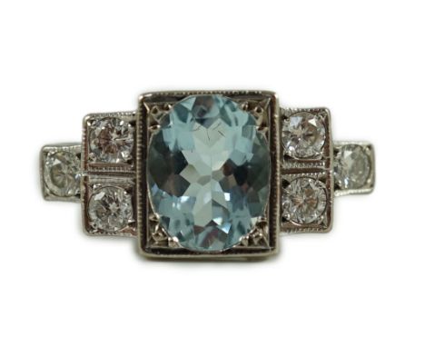 An 18ct white gold oval cut aquamarine and six stone diamond cluster set dress ring, size O, gross 4.8 grams.A couple of tiny