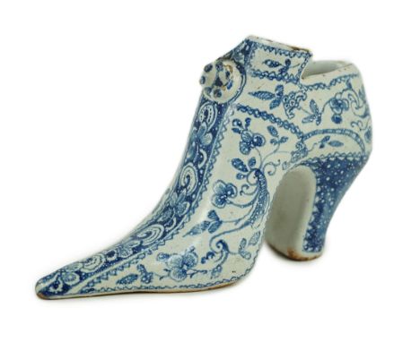 A documentary English delftware blue and white model of a shoe, dated 1732, painted with bands of flowers and scrolls, the un