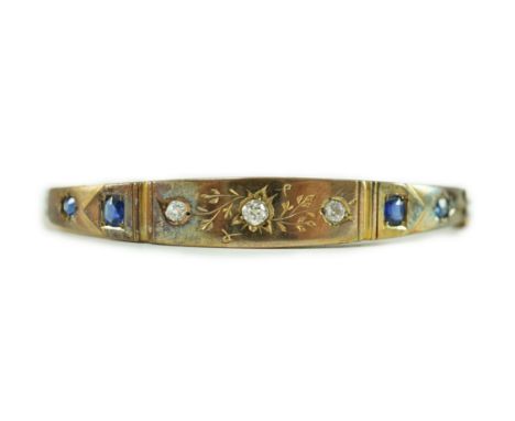 A late Victorian engraved gold, gypsy set three stone diamond and four stone sapphire set hinged bangle, interior diameter 54