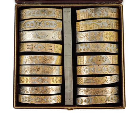 A Victorian cased travelling polychromatic metal bangle template set, containing eighteen numbered assorted mainly foliate de