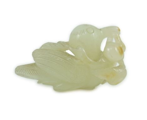 A Chinese pale celadon jade figure of a bird grasping a fruit sprig, 18th/19th century, the stone with a few small russet inc