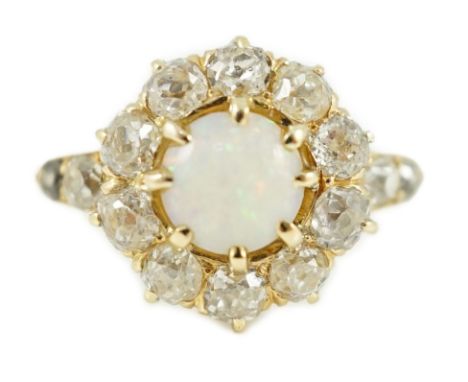 An early 20th century gold, white opal and diamond set circular cluster ring, with graduated diamond set shoulders, size T, g