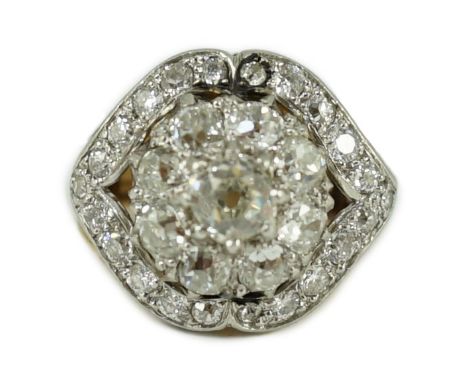 An early to mid 20th century continental gold and diamond set shaped circular cluster ring, set with old cut stones, the cent