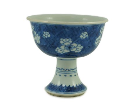 A Chinese blue white stem cup, Kangxi period, the bowl decorated with prunus blossom on cracked ice, the stem with leaf lappe