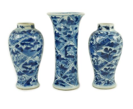 A garniture of three Chinese blue and white vases, Kangxi period, each painted with landscape vignettes within trellis shaped