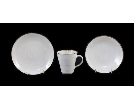 Dame Lucie Rie (1902-1995) a cup, saucer and side plate, c.1959, each white glazed stoneware with manganese rims, impressed L