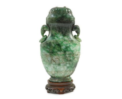 A Chinese archaistic green jadeite vase and cover, late Qing dynasty, with a pair of elephant head ring handles, above bands 