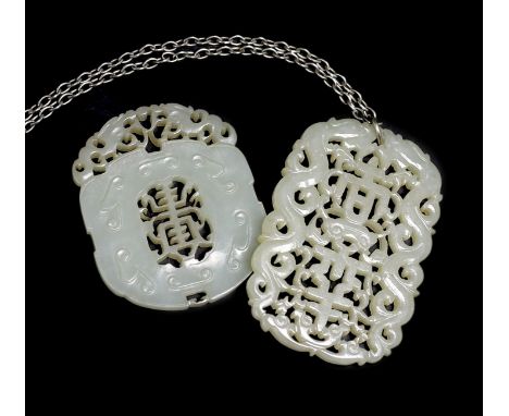 Two Chinese pale celadon jade openwork plaques, 19th century, each pierced with the character ‘shou’, 5.4 cm and 6.4 cmThe sm