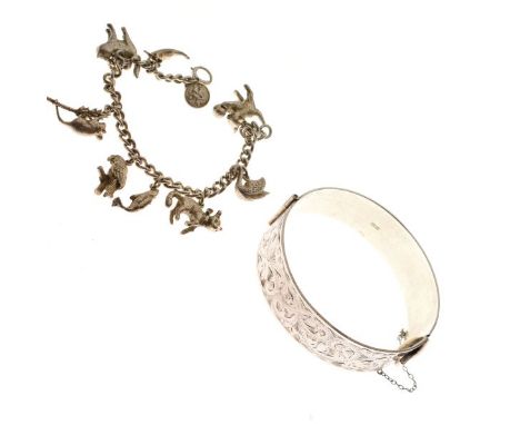 Engraved silver snap bangle and a silver charm bracelet attached various charms   Condition: 