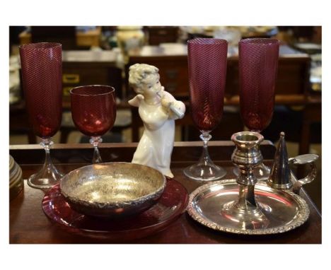 Three cranberry glass champagne flutes having wrythen-moulded bowls, together with a matching wine glass and a similar dish, 