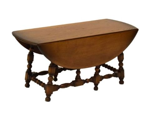 Ercol oval low coffee table of gateleg design with blocked and turned supports   Condition: 