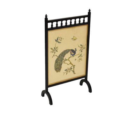 Early 20th Century ebonised oak firescreen decorated with a needlework panel of a perching peacock beneath turned balustrade 