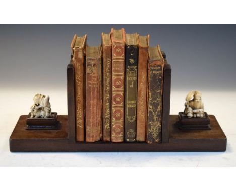 Early 20th Century mahogany book rack mounted with two ivory netsuke and a small quantity of leather bound books   Condition: