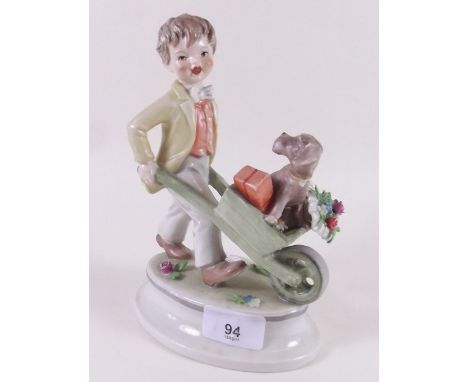 A large Hummel/Goebel figure of a boy with wheel barrow carrying a dog 