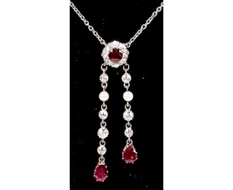 An Edwardian diamond and ruby set pendant necklace with two ruby, diamond and seed pearl asymmetrical drops 