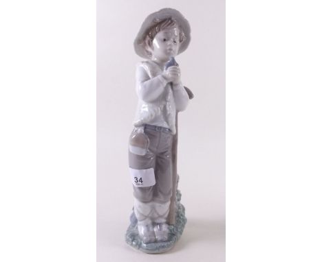 A large Lladro Nao figure, boy shepherd holding a bird - 27cm 