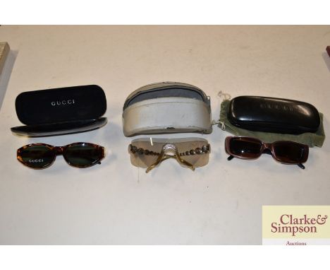Two pairs of Gucci glasses, and a pair of Christian Dior glasses