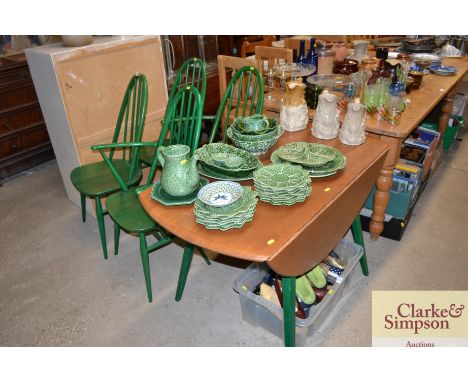 A part painted Ercol drop leaf kitchen table and four stick back chairs, two standards and two elbows 