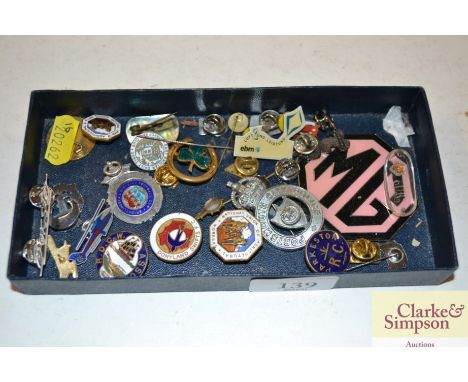 A box containing various badges; a silver sporting medal; an enamel stick pin etc. 