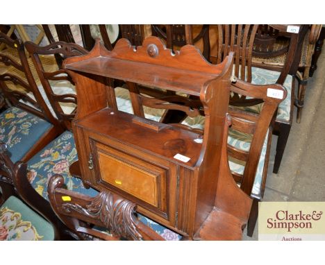 A mahogany hanging wall shelf with cupboard below 