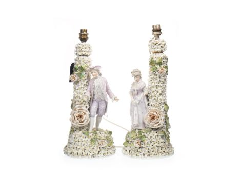 PAIR OF VICTORIAN CERAMIC FIGURAL LAMP BASES, one depicting the figure of a lady and the other a gentleman, each modelled in 