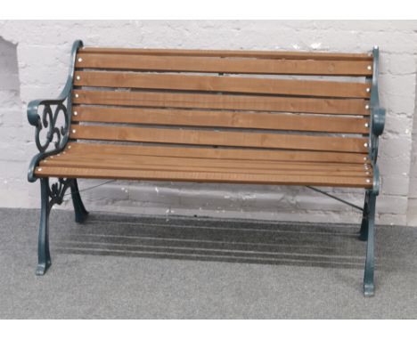 A three seat garden bench with painted cast iron ends.