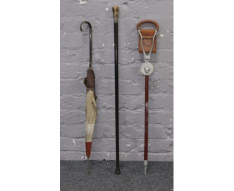 A ebonised walking cane with horn pommel and silver collar, along with a vintage parasol and a shooting stick.