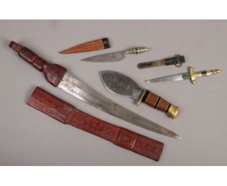 Four eastern knives including one in leather scabbard and one with Damascus steel blade.