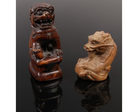 A carved fruit wood netsuke formed as a dragon, signed along with a carving of a dog of fo.