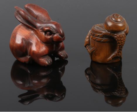 Two carved fruit wood netsuke one formed as slugs on a barrel the other as a hare with glass set eyes, one signed.