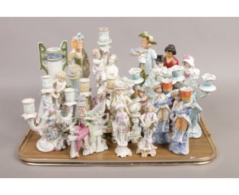 A collection of ceramic figural candlesticks and vases to include bisque examples and a Sitzendorf style with a cherub.