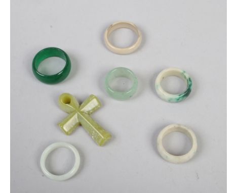 Six jade coloured hardstone rings, along with a similar crucifix.
