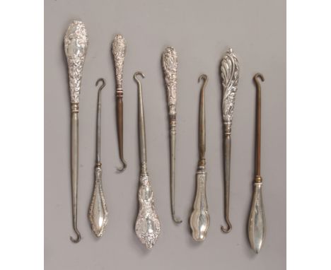 A collection of eight silver handled button hooks, various assay marks.