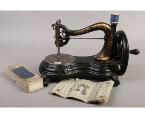 A vintage Jones hand crank sewing machine with instruction manual.