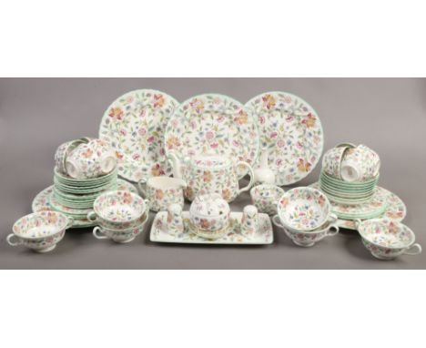 A large quantity of Minton teawares in The Haddon Hall design to include teapot, cup and saucers, sugar bowl, preserve pot et