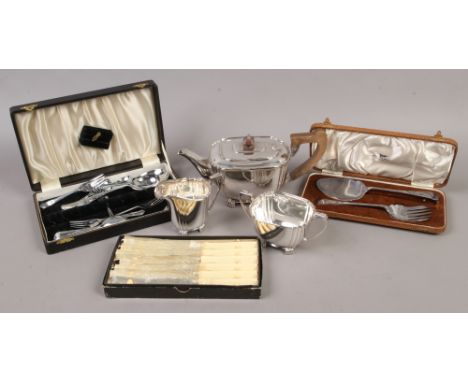A silver plate three piece tea service along with three cased cutlery sets.