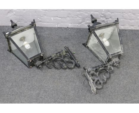 A pair of Victorian style priory metal lanterns with decorated metal wall bracket.