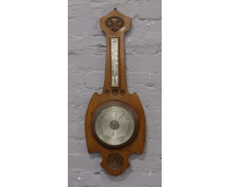 A large carved oak banjo barometer with silvered dial.